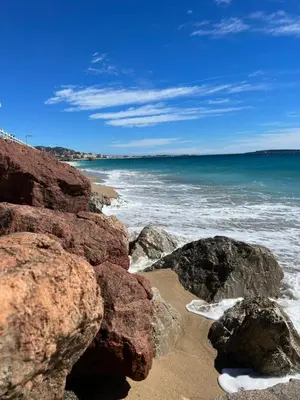 a beach with some rocks and the ocean at Cannes Center Appartement F9 in Cannes