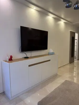 a white entertainment center with a flat screen tv on a wall at Cannes Center Appartement F9 in Cannes
