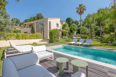 a backyard with a pool and chairs and a house at 002 Villa Camille in Cannes