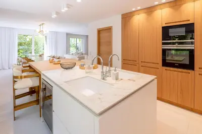 a kitchen with a white counter top and wooden cabinets at 002 Villa Camille in Cannes