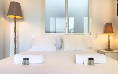 a bedroom with a white bed with a window at 303 Le Gallia in Cannes