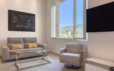 a living room with a couch and a chair and a tv at 303 Le Gallia in Cannes