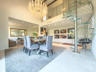 a dining room with a table and a spiral staircase at Eclat by Winsome Destination in Cannes