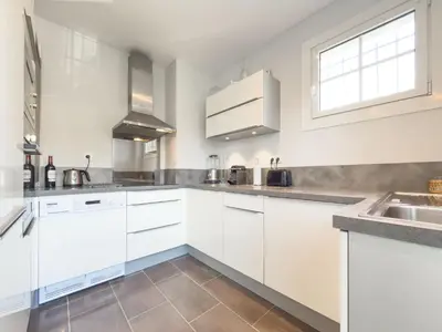 a kitchen with white cabinets and a sink at Eclat by Winsome Destination in Cannes