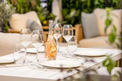 a table with glasses and a bottle of wine on it at Magnifique appartement à 50 mètres de la Croisette in Cannes