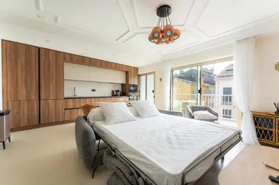 a bedroom with a large bed and a kitchen at Magnifique appartement dans le carré d'or à Cannes in Cannes