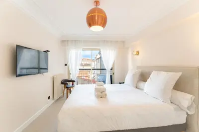 a bedroom with a white bed with a teddy bear on it at Magnifique appartement dans le carré d'or à Cannes in Cannes