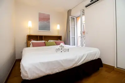 a large white bed in a room with a window at SUITE DE LUXE PINK LADY 4P in Cannes