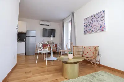 a kitchen and a living room with a table and chairs at SUITE DE LUXE PINK LADY 4P in Cannes