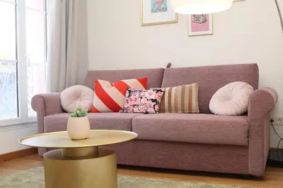 a living room with a purple couch with pillows and a table at SUITE DE LUXE PINK LADY 4P in Cannes