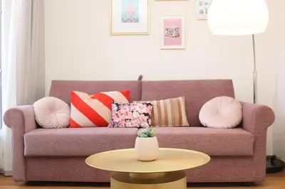 a living room with a couch with pillows and a table at SUITE DE LUXE PINK LADY 4P in Cannes