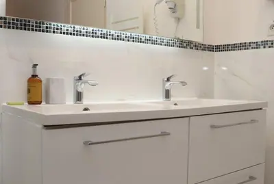 a white bathroom with a sink and a mirror at SUITE DE LUXE PINK LADY 4P in Cannes