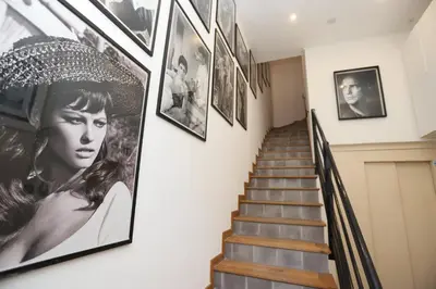 a hallway with pictures on the wall and stairs at SUITE DE LUXE PINK LADY 4P in Cannes