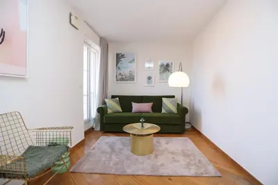 a living room with a green couch and a table at SUITE DE LUXE VERVEINE 4P in Cannes