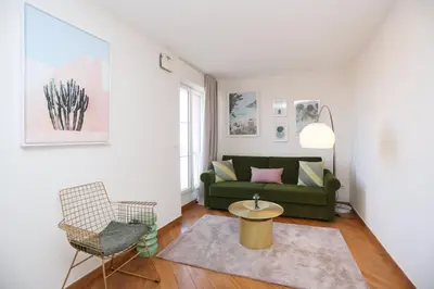 a living room with a green couch and a table at SUITE DE LUXE VERVEINE 4P in Cannes