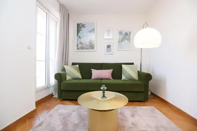 a living room with a green couch and a gold table at SUITE DE LUXE VERVEINE 4P in Cannes