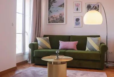 a living room with a green couch and a table at SUITE DE LUXE VERVEINE 4P in Cannes