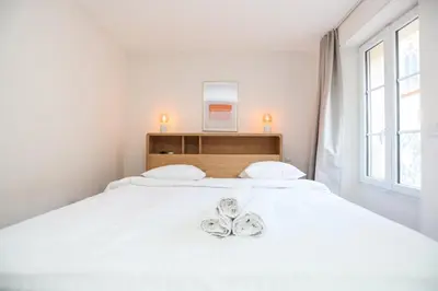 a bedroom with a white bed with two shoes on it at SUITE DE LUXE MANDARINE 4P in Cannes
