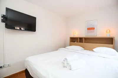 a bedroom with a bed with a flat screen tv on the wall at SUITE DE LUXE MANDARINE 4P in Cannes