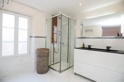 a bathroom with a glass shower and a sink at SUITE DE LUXE MANDARINE 4P in Cannes
