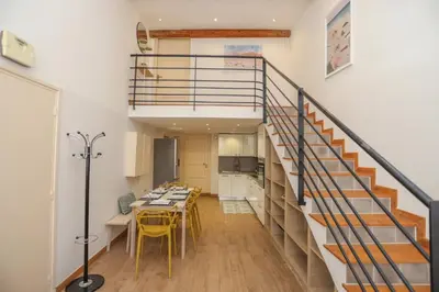 a room with a staircase and a table and chairs at SUITE DE LUXE MIMOSA 6P in Cannes