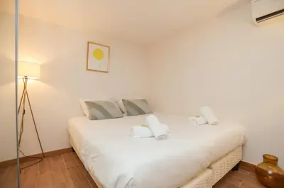 a bedroom with a white bed with towels on it at SUITE DE LUXE MIMOSA 6P in Cannes