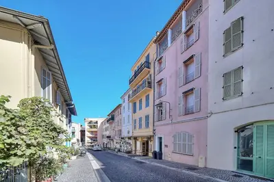 an empty street with pink and yellow buildings at SUITE DE LUXE MIMOSA 6P in Cannes