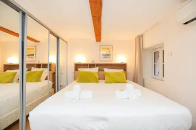 a bedroom with two beds with yellow and green pillows at SUITE DE LUXE MIMOSA 6P in Cannes