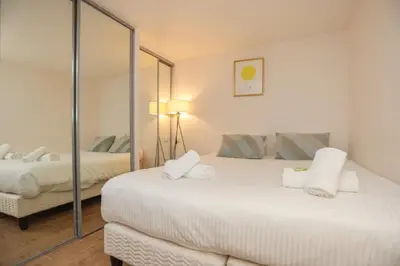 a bedroom with two beds and a mirror at SUITE DE LUXE MIMOSA 6P in Cannes