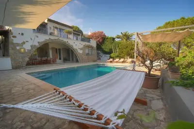 a hammock in front of a house with a swimming pool at Villa Lou Bayou French Riviera near Cannes in Vallauris