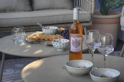 a bottle of wine sitting on a table with wine glasses at Villa Lou Bayou French Riviera near Cannes in Vallauris