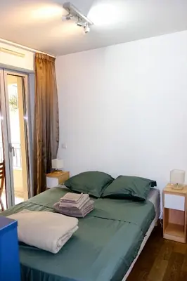 a bedroom with a bed with green sheets and a window at Quiet Appartment 400m Palais & 100m Beach in Cannes