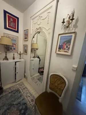 a living room with a mirror and a chair at Suite Romantic in Cannes
