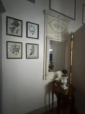 a room with a mirror and a table with a vase at Suite Romantic in Cannes