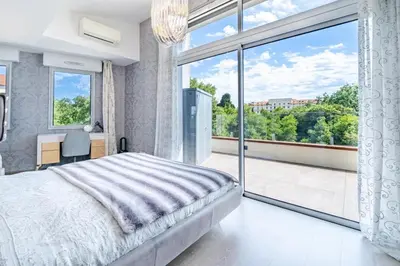 a bedroom with a bed and a large window at Oxford-Californie Luxury 4-Bedroom Penthouse With Parking in Cannes