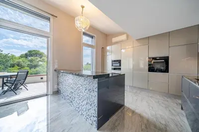 a kitchen with a large island with a black counter top at Oxford-Californie Luxury 4-Bedroom Penthouse With Parking in Cannes