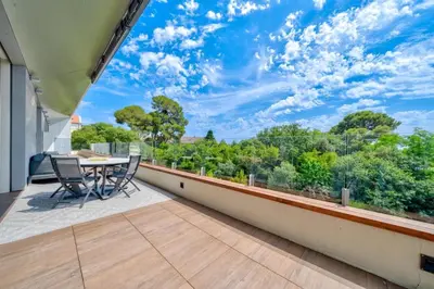 a patio with a table and chairs on a balcony at Oxford-Californie Luxury 4-Bedroom Penthouse With Parking in Cannes