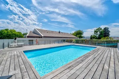 a swimming pool on a wooden deck next to a house at Oxford-Californie Luxury 4-Bedroom Penthouse With Parking in Cannes