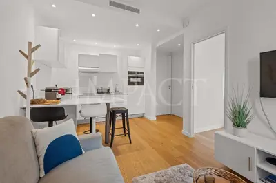 a living room with a couch and a kitchen at REF 2023- Cannes Croisette - Apartment to rent in Cannes