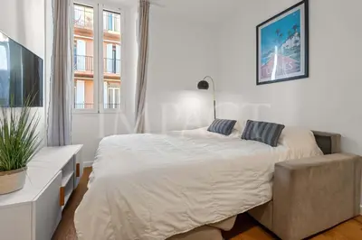 a white bedroom with a bed and a chair at REF 2023- Cannes Croisette - Apartment to rent in Cannes
