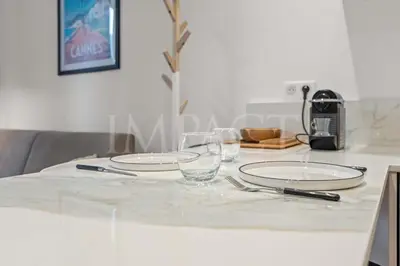 a table with two plates and glasses on it at REF 2023- Cannes Croisette - Apartment to rent in Cannes