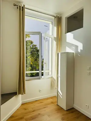 a kitchen with a refrigerator and a window at Studio Design Climatisé Cœur de Cannes in Cannes