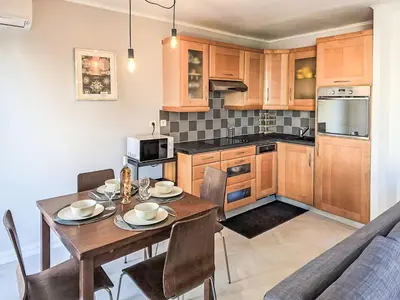a kitchen with a wooden table and a dining room at Apartment Reine Astrid-5 by Interhome in Cannes