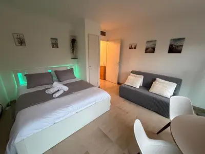 a bedroom with a white bed and a couch at Studio Suquet proche palais des festivals congrès in Cannes