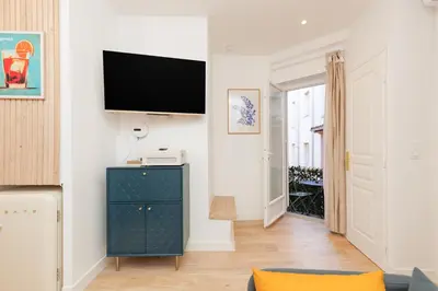 a living room with a blue cabinet and a flat screen tv at Aurea YourHostHelper in Cannes