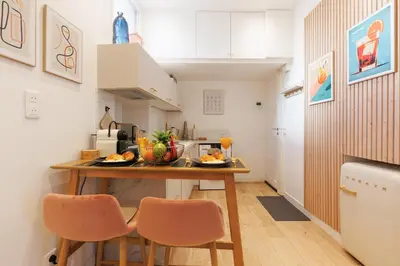a small kitchen with a table and two chairs at Aurea YourHostHelper in Cannes