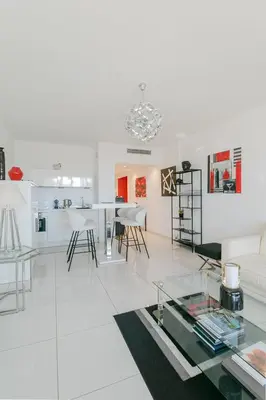a white living room with a table and chairs at Le Venus in Cannes