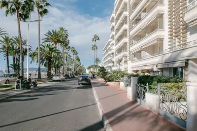 a city street with palm trees and a building at Le Venus in Cannes