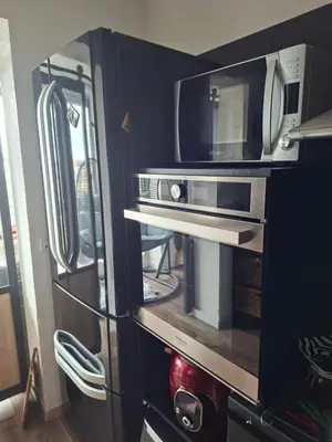 a kitchen with a microwave and a refrigerator at Location saisonnière T3 Cannes in Cannes