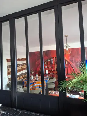 a room with a large window with a table at Location saisonnière T3 Cannes in Cannes